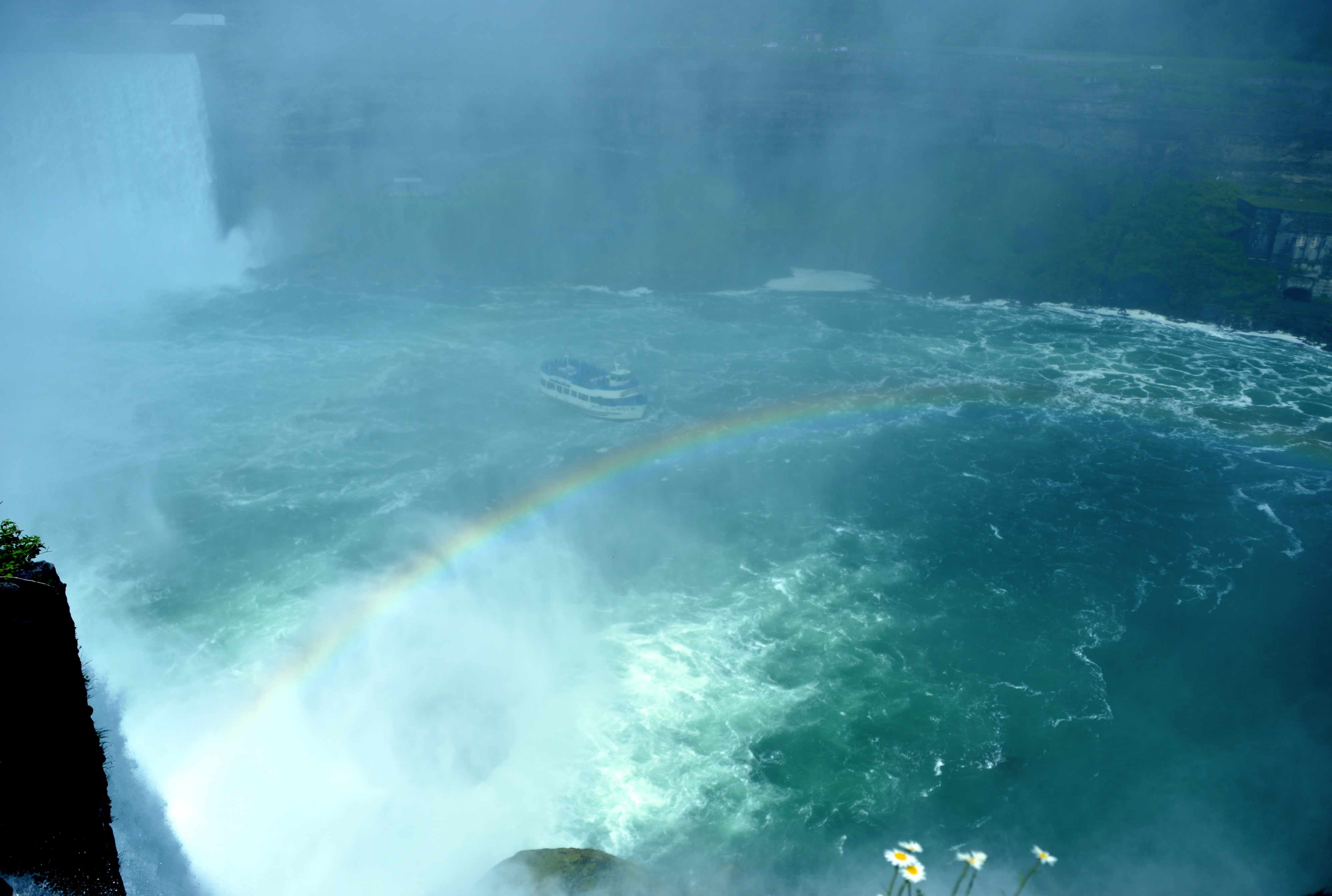 A rainbow arches across the water as the Maid Of the Mist approaches Niagara Falls City in New York.